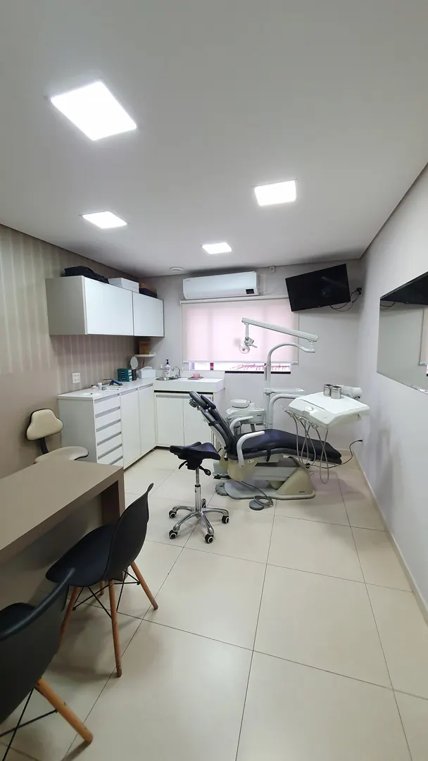 Consultório com cadeira odontológica, bancada de trabalho e armários