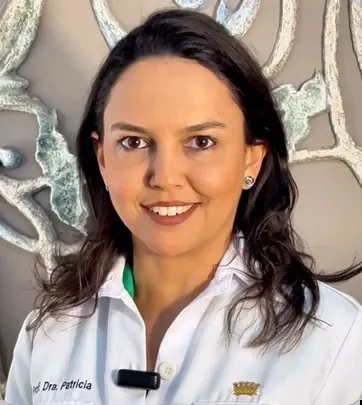Dra. Patricia Garani sorrindo, de jaleco branco, em uma sala da Mariani Odontologia