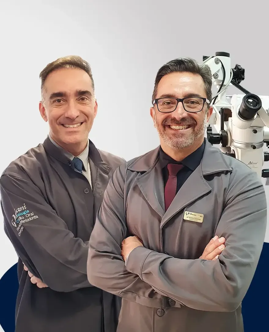 Dr. Rafael Mariani e Dr. Rodrigo Mariani, de jaleco da clínica, ao lado do microscópio operatório